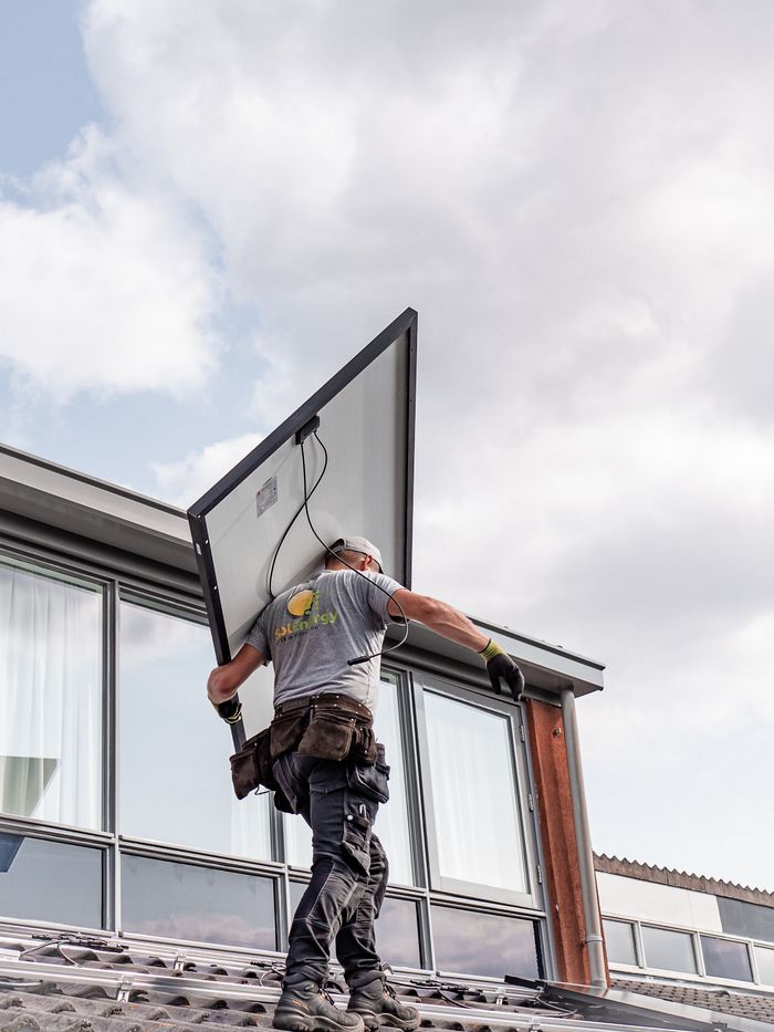 Mastering the First Impression: Your intriguing post title goes here A worker installs a solar panel on a residential rooftop emphasizing renewable energy.